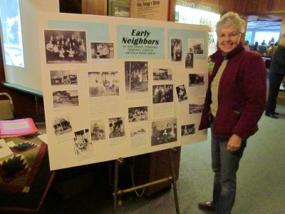 Photo of member Punky Scott standing in front of a history display at the OLHD booth in the Milwaukie Elks Lodge
